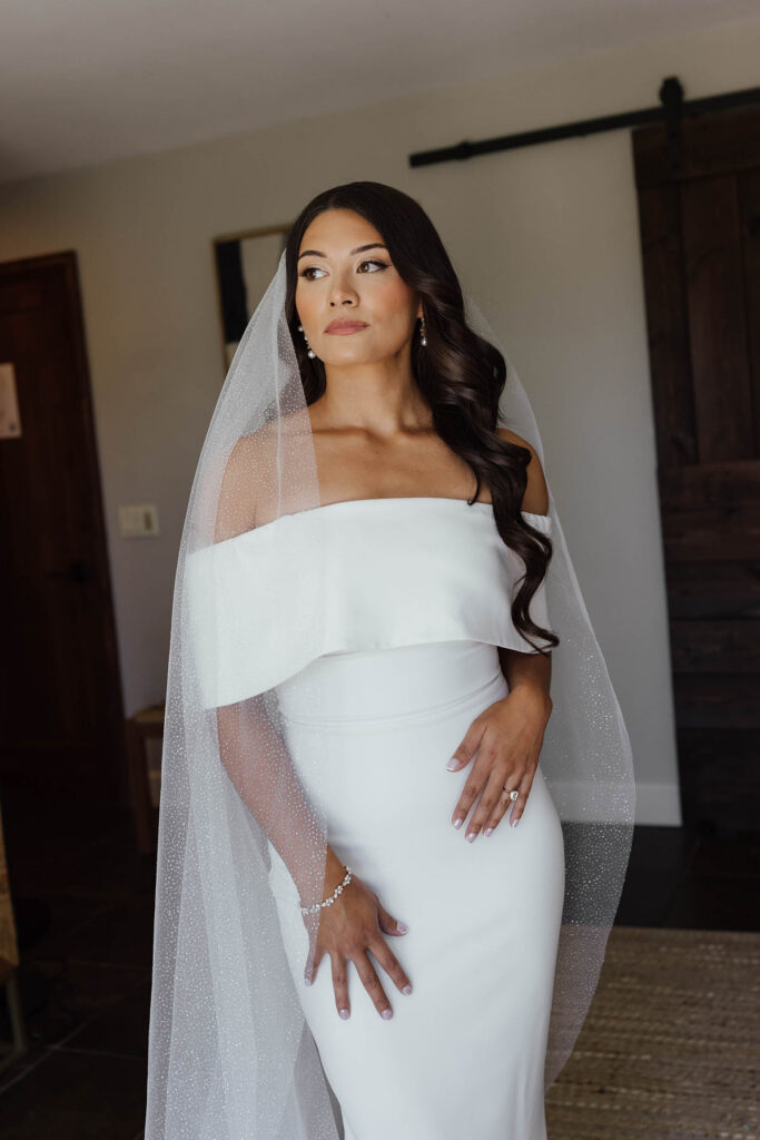 The bride poses in her off-the-shoulder gown and veil before her Emerald Bay Lake Tahoe elopement