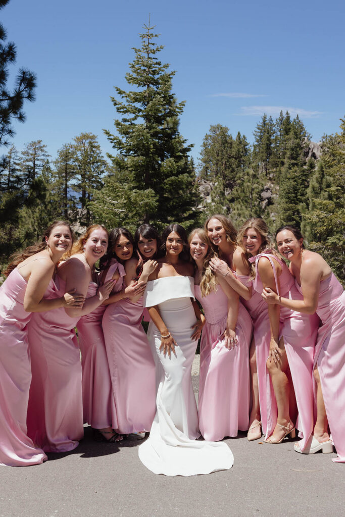 The bride poses with her bridesmaids in pink dresses before the Emerald Bay ceremony