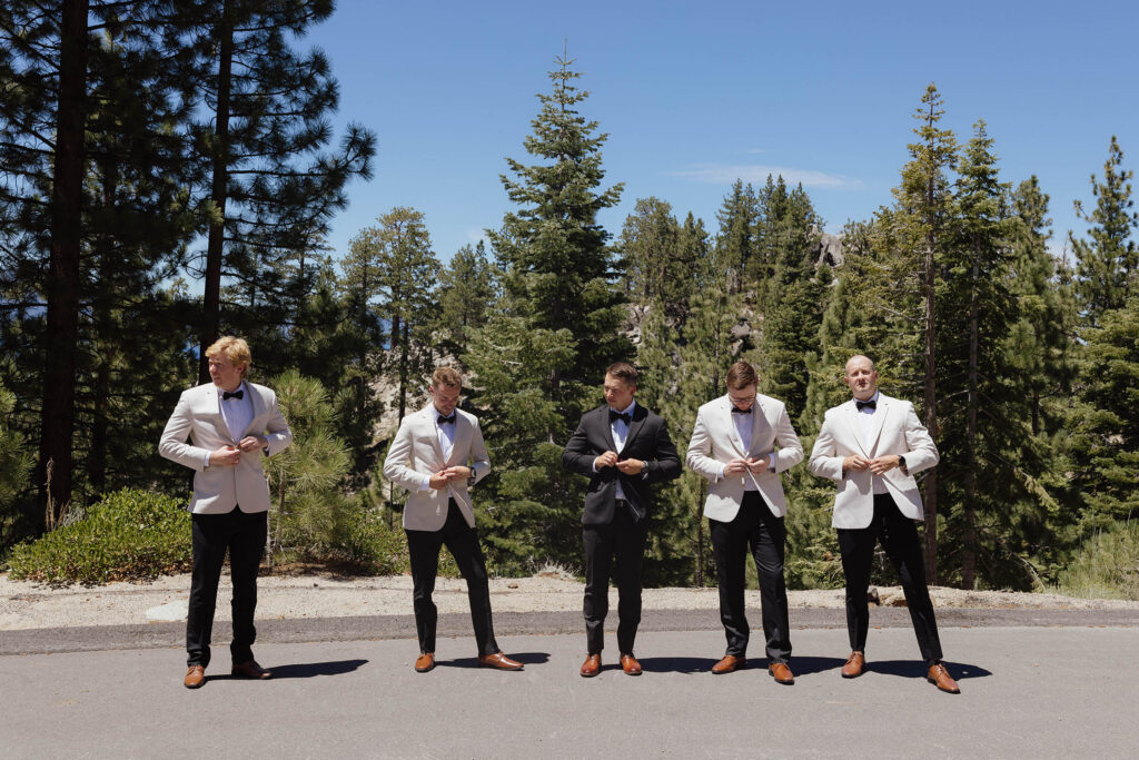 The groom and groomsmen button their jackets during wedding party portraits in Lake Tahoe