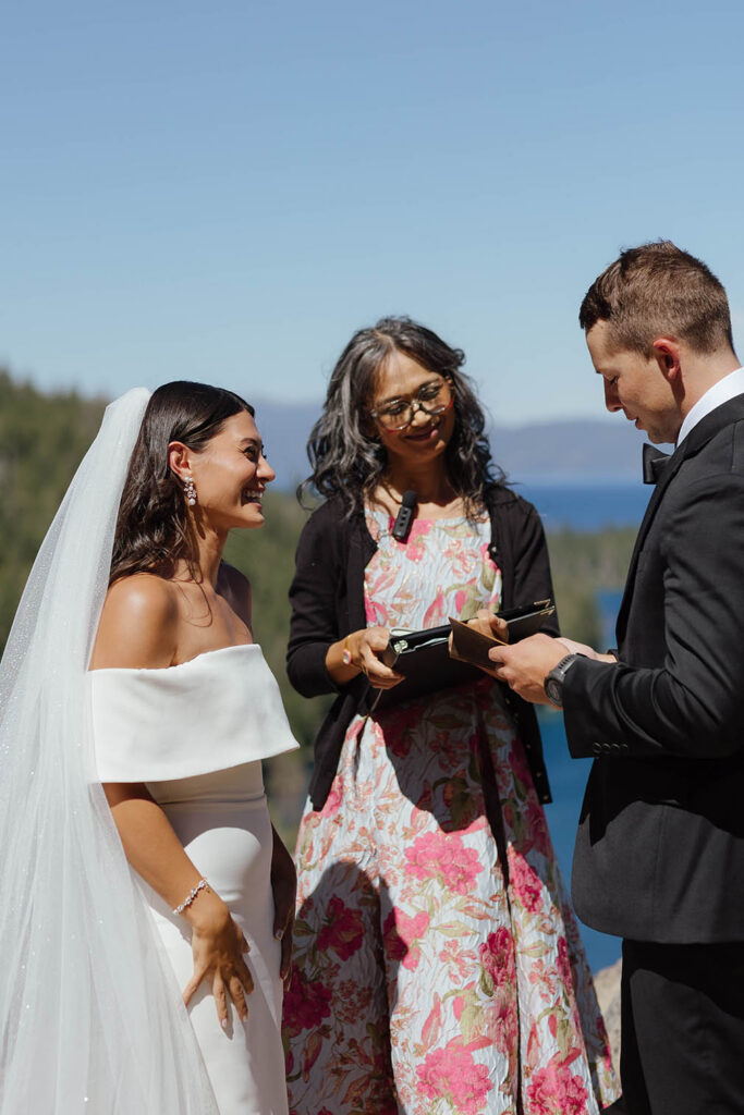 The bride and groom exchange vows overlooking the blue water and forested shoreline of Emerald Bay