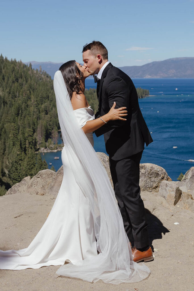 The bride and groom share their first kiss as newlyweds overlooking Emerald Bay in Lake Tahoe
