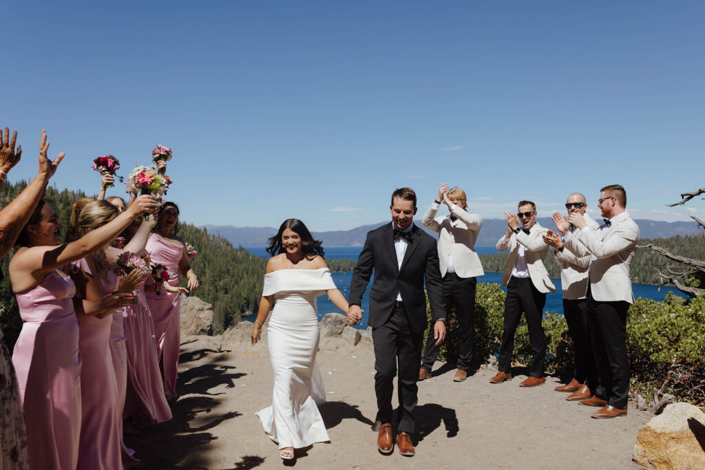 The bride and groom walk through their cheering wedding party after their Emerald Bay ceremony