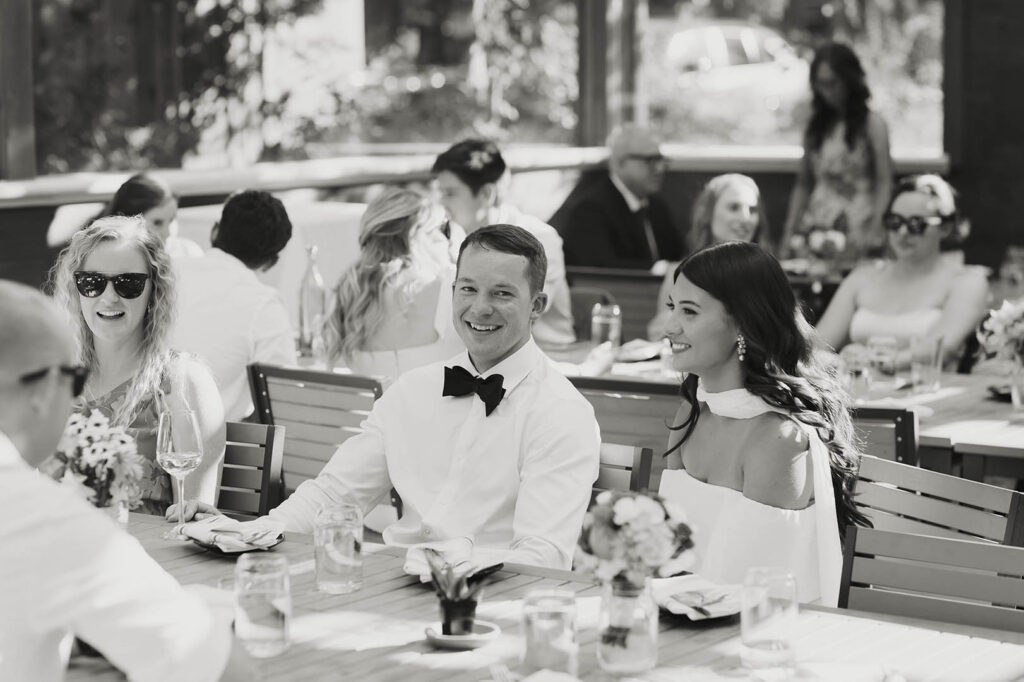 The bride and groom smile together while listening to a toast at their Lake Tahoe wedding reception