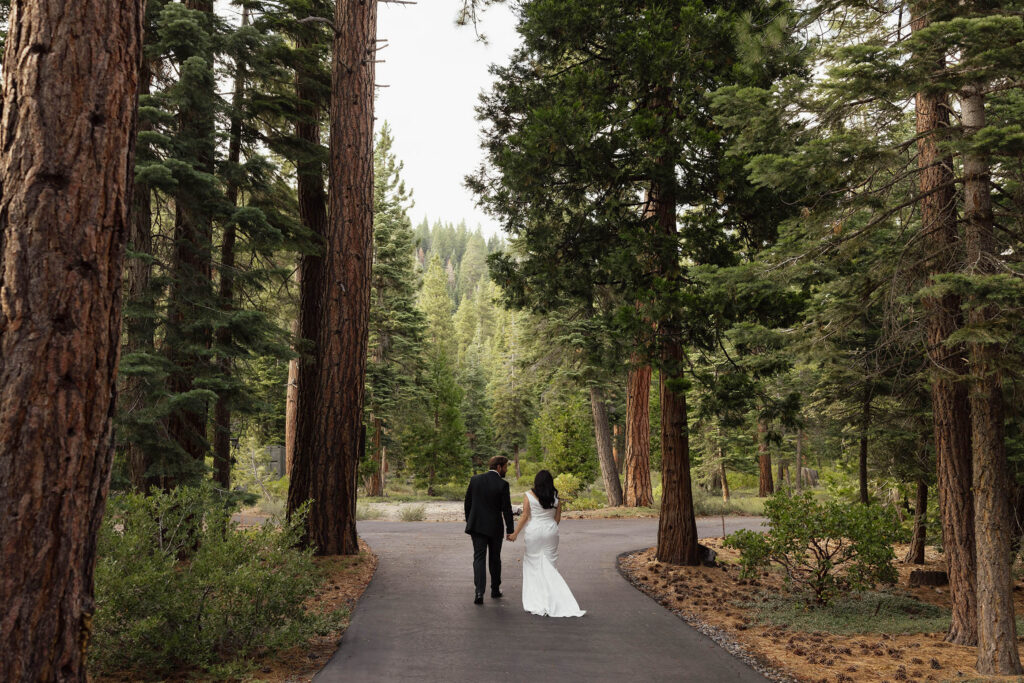 Bride and groom walking withe pine trees surrounding them in Lake Tahoe