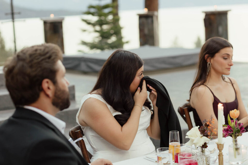 Bride wipes away tears during the outdoor wedding reception in Lake Tahoe