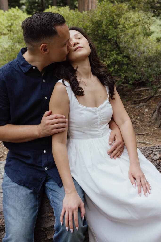 Man kissing fiancé on cheek while she leans on him with her eyes closed at Emerald Bay