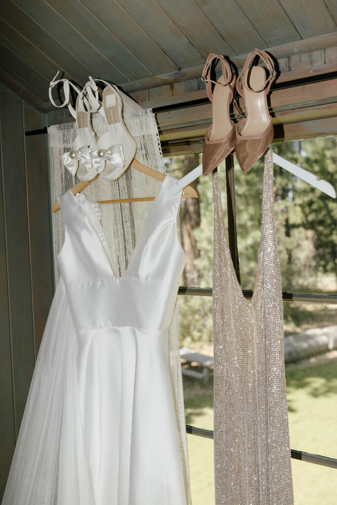 Wedding dress, sparkling reception dress, and coordinating heels hanging at Valhalla Tahoe