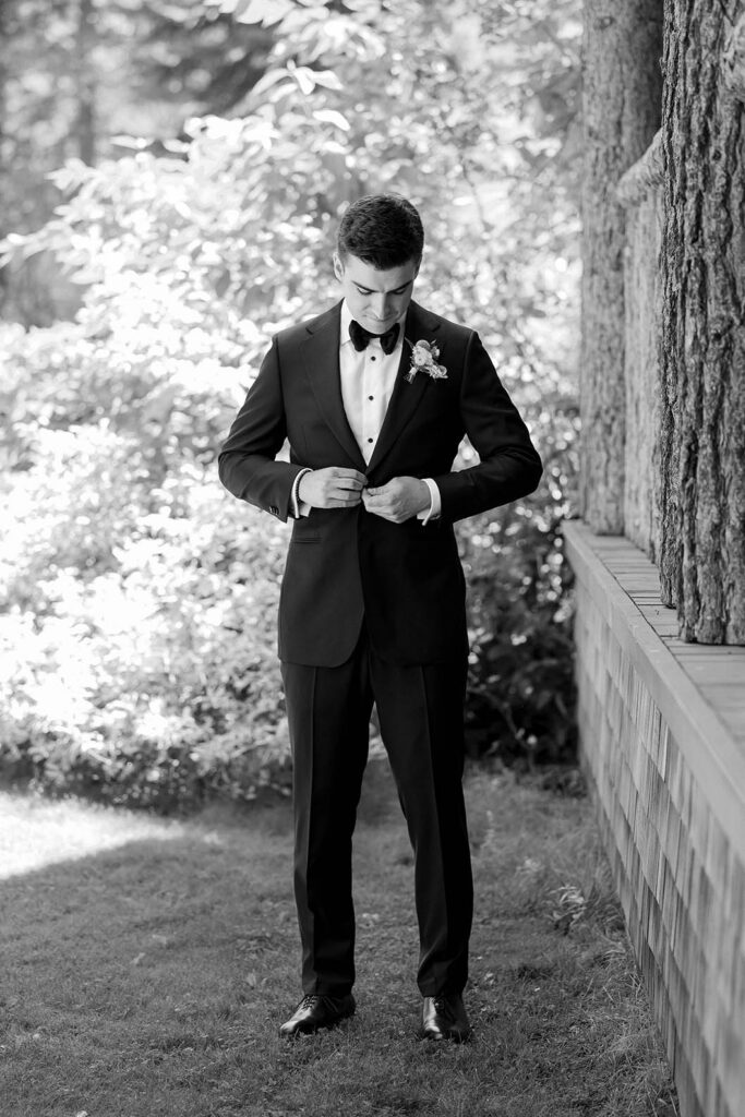 Groom buttoning his black tuxedo outdoors before the Valhalla Tahoe ceremony
