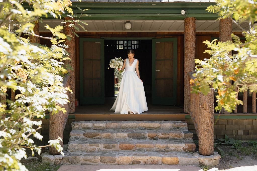 Bride holds a white floral bouquet outside a rustic cabin at Valhalla Tahoe