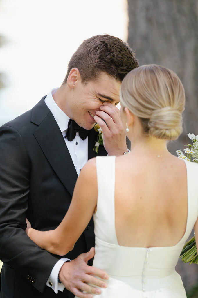 Emotional groom wipes away a tear while embracing the bride during their Valhalla Tahoe wedding