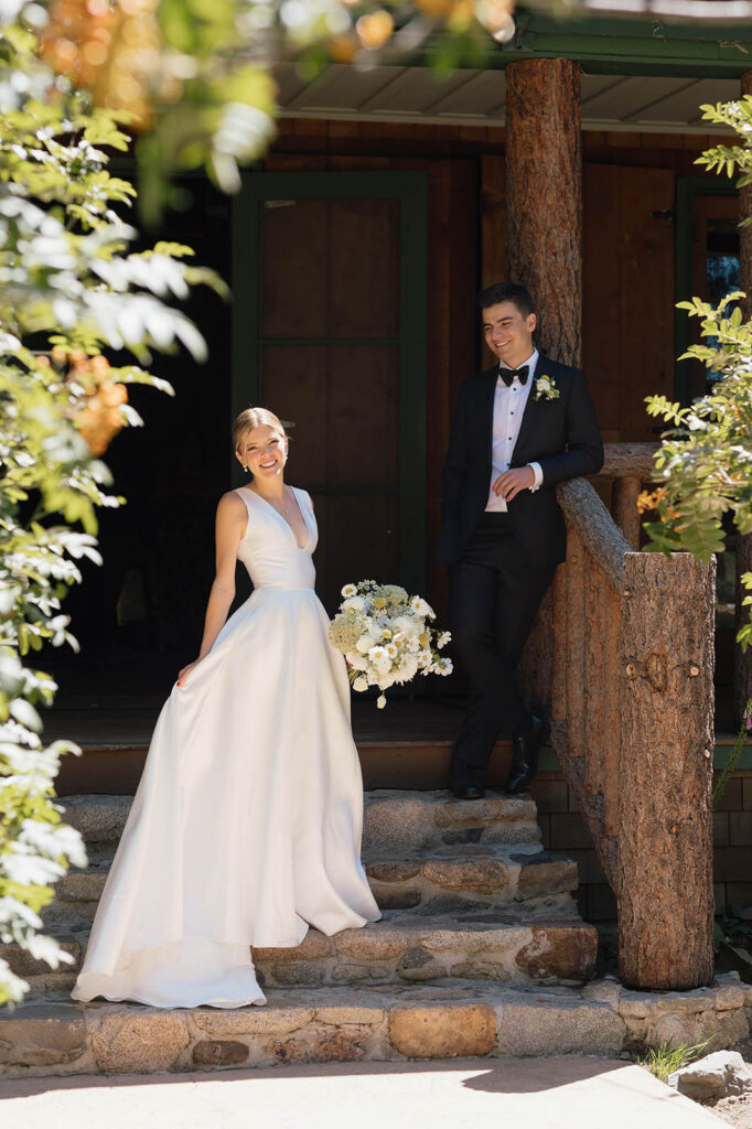 Bride and groom pose on the steps of a rustic cabin at Valhalla Tahoe