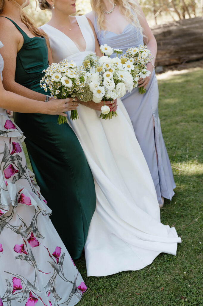 Close-up of the bride and bridesmaids holding white daisy bouquets