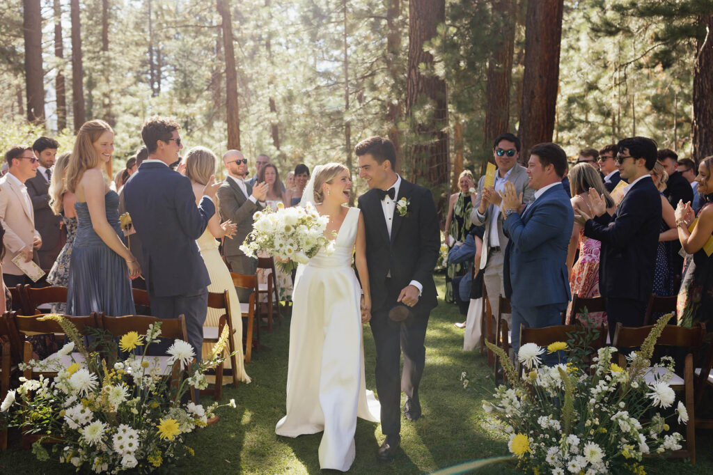 Newlyweds walk down the aisle as guests cheer during their Lake Tahoe wedding
