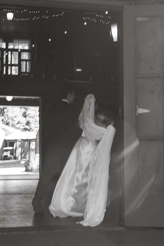 Black-and-white photo of the newlyweds sharing a private embrace inside Valhalla Tahoe
