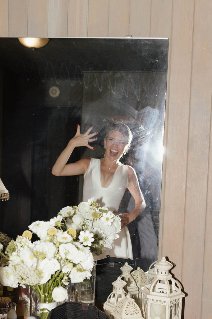 Bride excitedly shows her wedding ring in the mirror after the ceremony