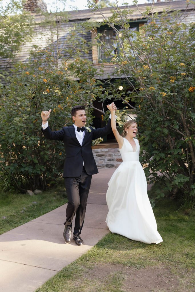 Newlyweds raise their hands and cheer as they enter their reception grand entrance at Valhalla Tahoe
