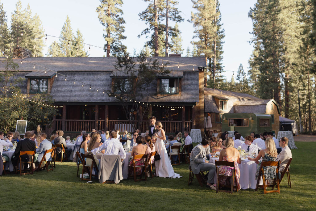 Summer wedding reception with seated guests, string lights, and a rustic Valhalla Tahoe lodge