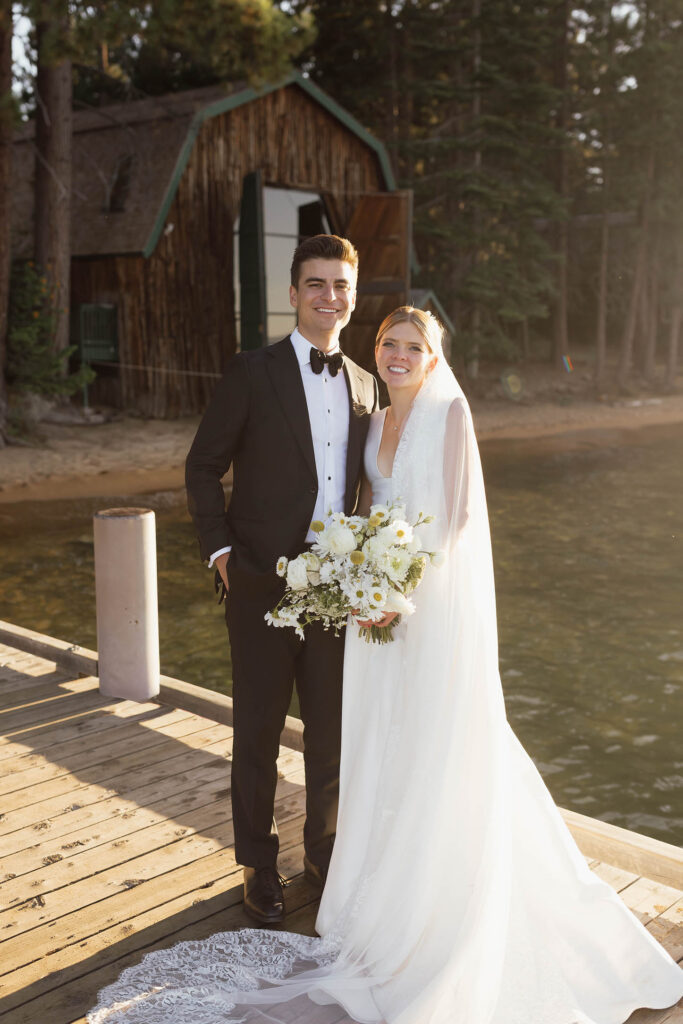 Bride and groom pose on the Valhalla Tahoe dock in warm evening light during sunset