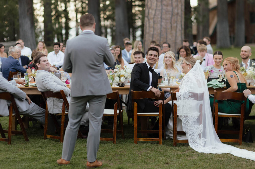 Groom and bride listen to a reception speech with guests at their Valhalla Tahoe summer wedding