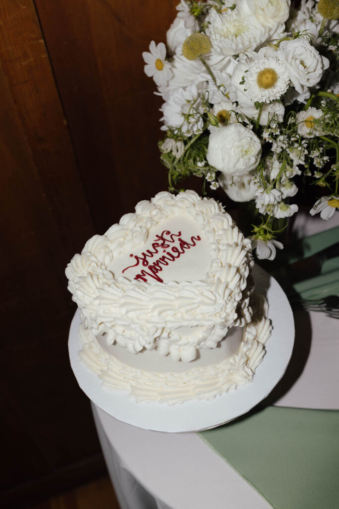 Heart-shaped Just Married cake with white flowers at a summer wedding at Valhalla Tahoe