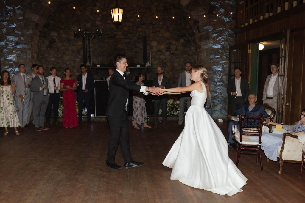 Bride and groom share their first dance as guests watch inside the historic Lake Tahoe venue