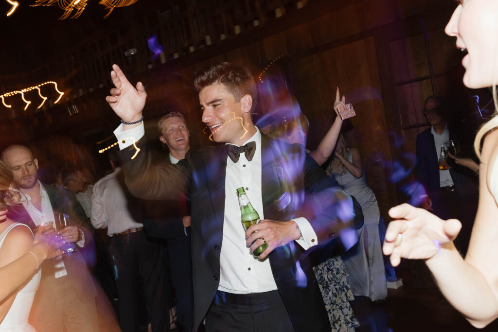 Groom dances with a beer in hand during the lively Valhalla Tahoe wedding reception