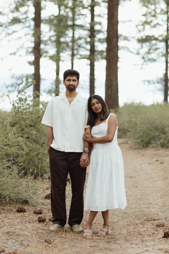 Engaged couple holding hands on a pine forest trail during their South Lake Tahoe engagement session