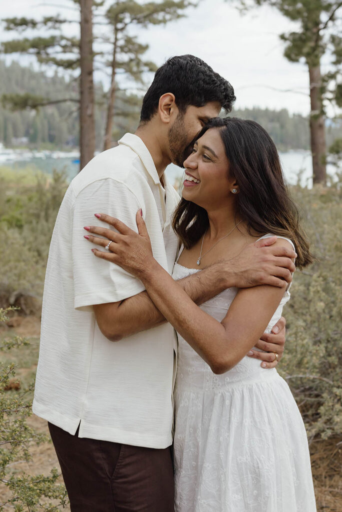 Man kissing his smiling fiancée on the cheek during their South Lake Tahoe engagement photos