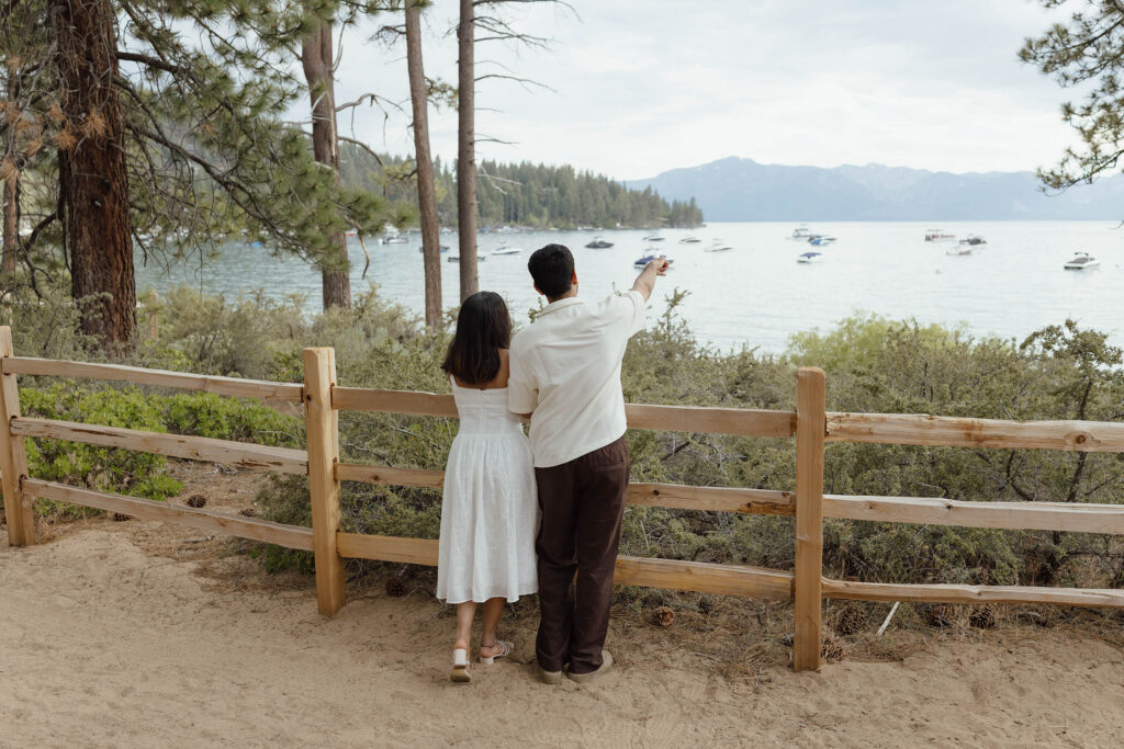 Couple enjoying the lake view during their South Lake Tahoe engagements while man points at something