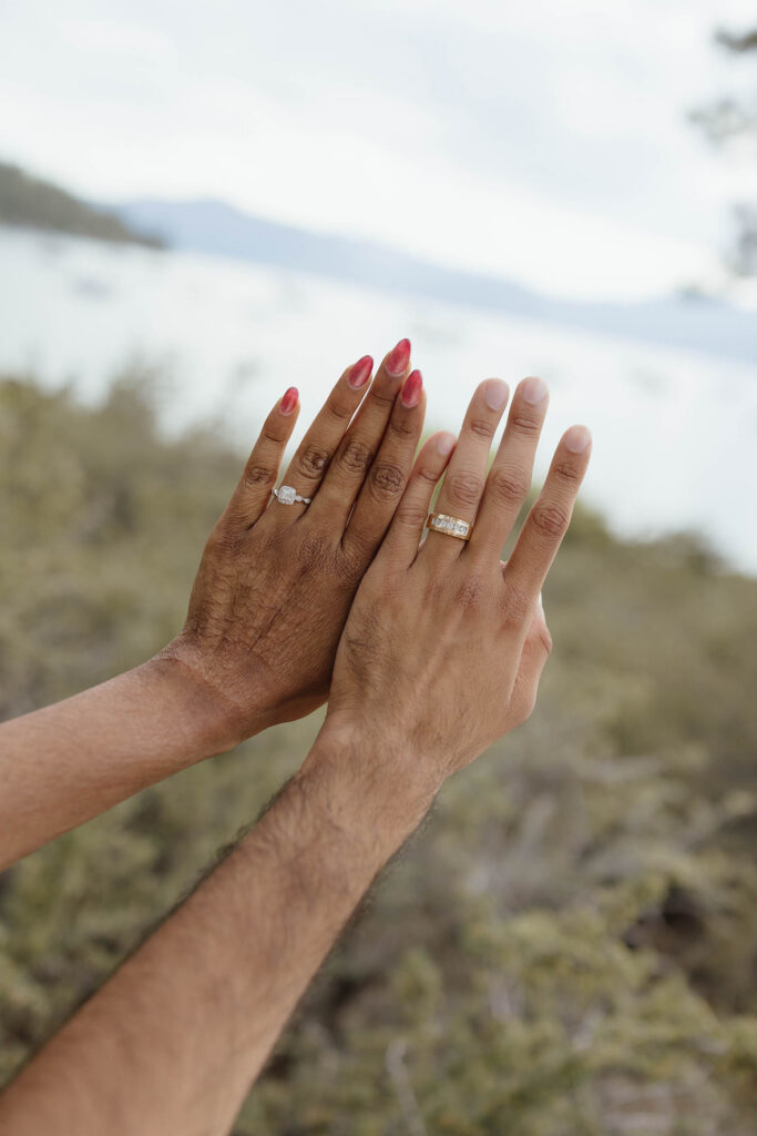 Close-up of the engaged couple showing their rings with Lake Tahoe in the background