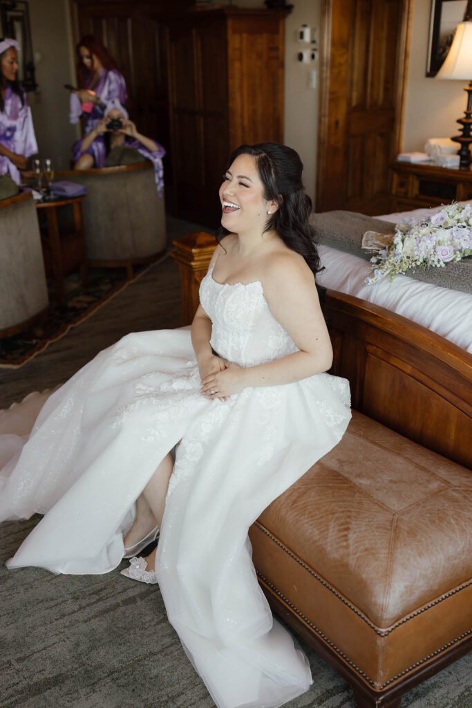 Bride laughing while getting ready in her wedding dress at Tahoe Blue Estate