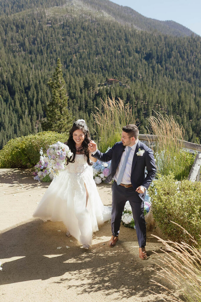 Bride and groom walking hand in hand through the mountain estate after saying their vows