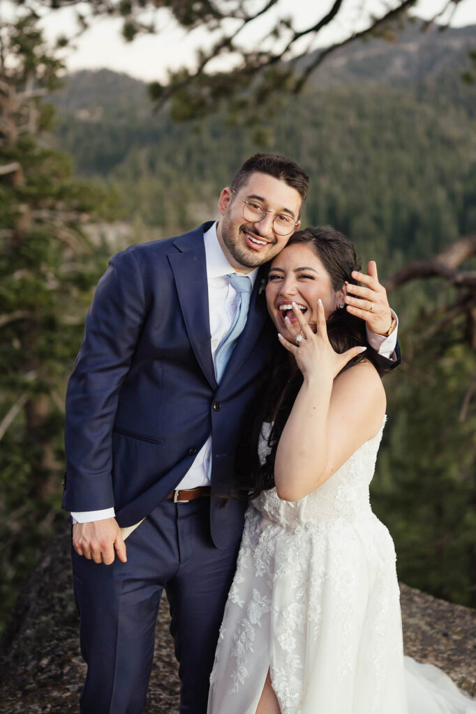 Laughing bride and groom showing off wedding rings in Lake Tahoe 