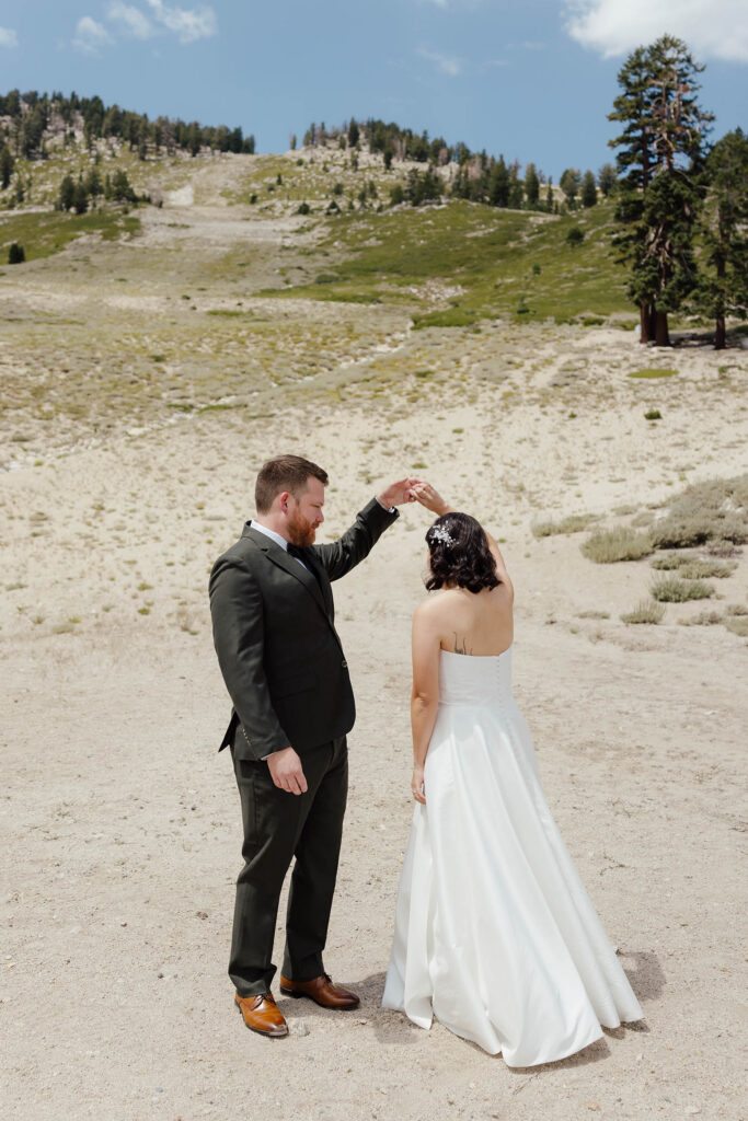 Groom twirling the bride beneath the summer ski slopes at Mt Rose