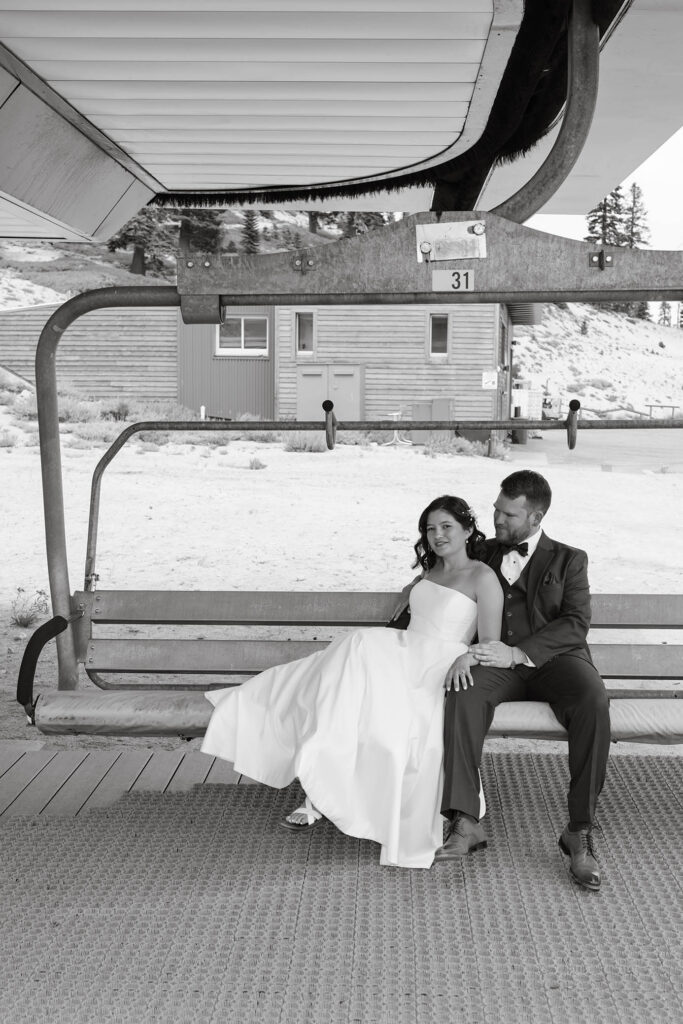 Black-and-white portrait of the bride and groom cuddling on a chairlift for their Winters Creek Lodge wedding