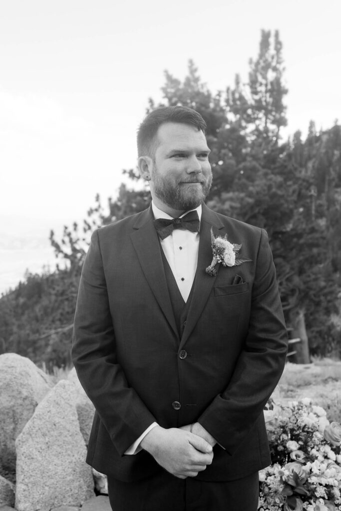 Black and white portrait of the groom waiting at the outdoor ceremony site at Winters Creek Lodge