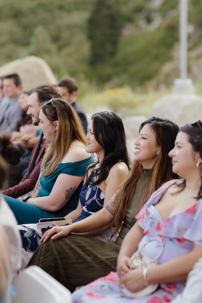 Wedding guests smiling as they watch the outdoor ceremony at Winters Creek Lodge near Lake Tahoe